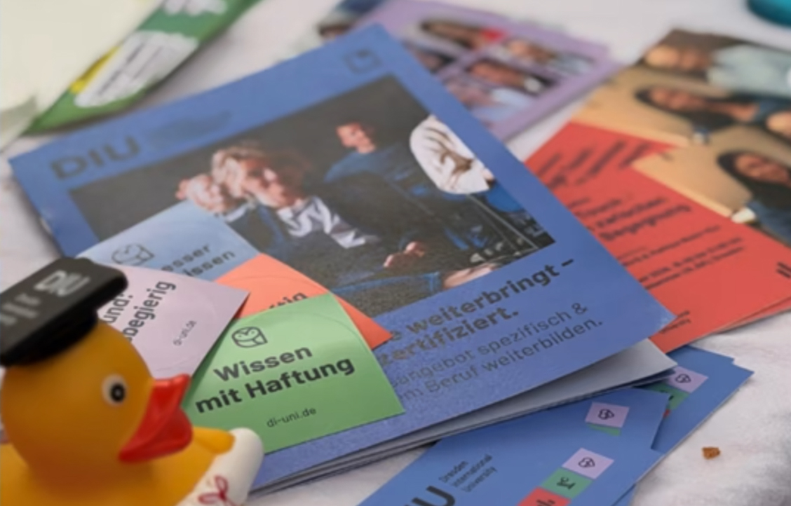 Nahaufnahme eines Stapels bunter Flyer mit einem DIU Gummi Ente