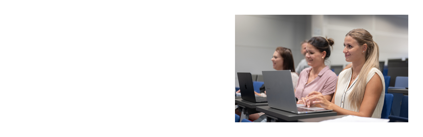 Studierende sitzen mit aufgeklappten Laptops im Hörsaal der DIU und verfolgen eine Vorlesung.