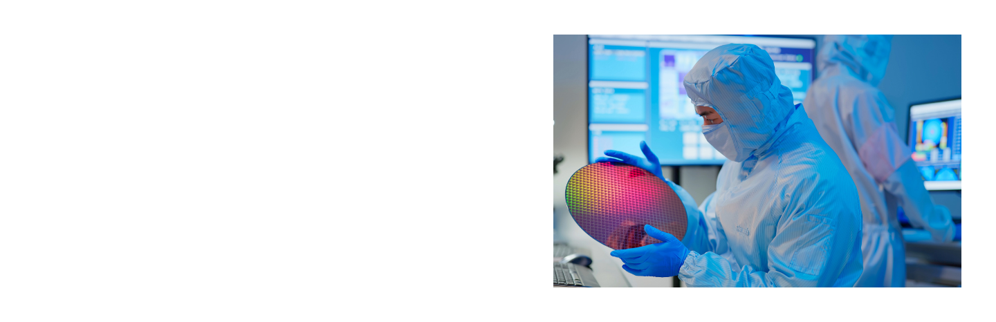 A technician in cleanroom protective gear inspects a semiconductor wafer in a high-tech production environment.