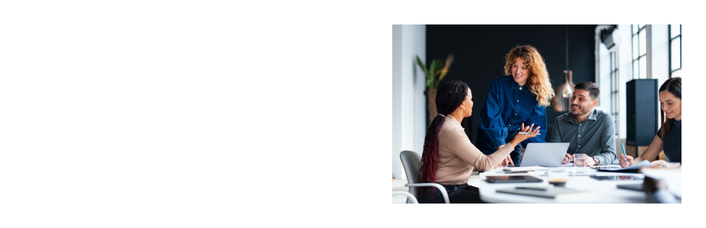Eine Gruppe von vier Personen diskutiert lebhaft an einem Besprechungstisch in einem modernen Büro.